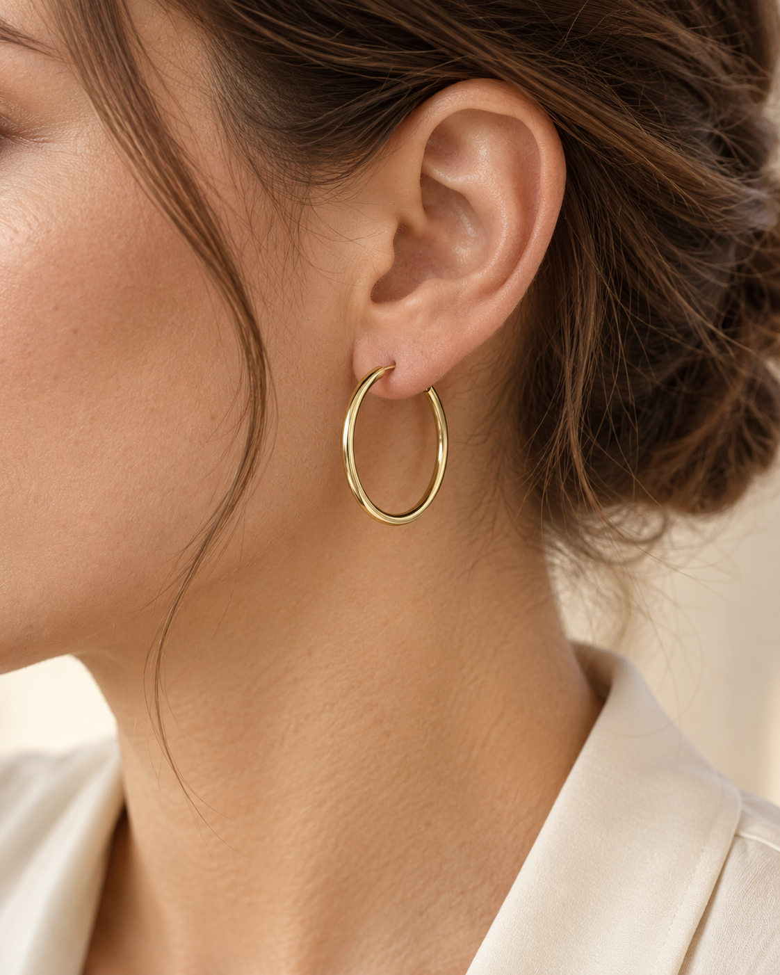 Créole ronde en or jaune 9 carats de 30 mm portée par une femme brune