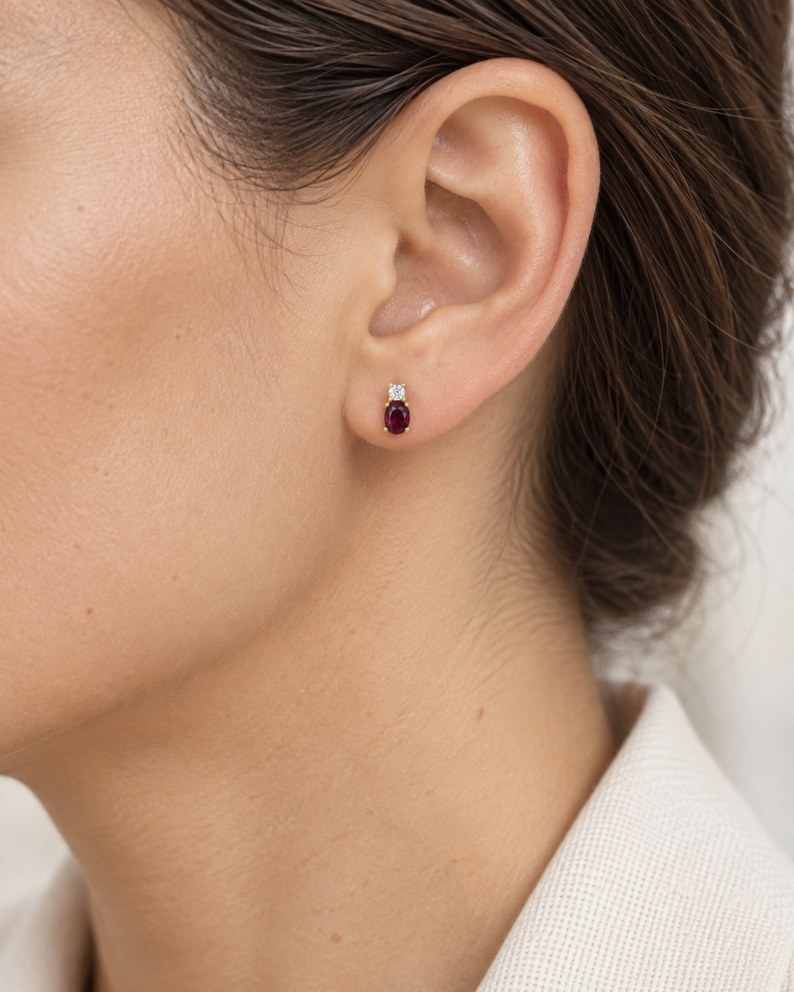 Boucles d’oreilles rubis et oxyde de zirconium en or jaune 9 carats portées par une femme