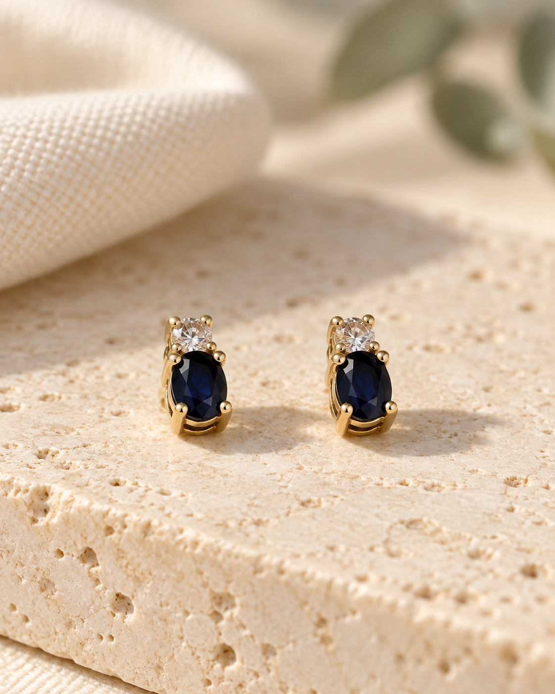 Boucles d’oreilles saphir et oxyde de zirconium en or jaune 9 carats sur un décor en pierre claire