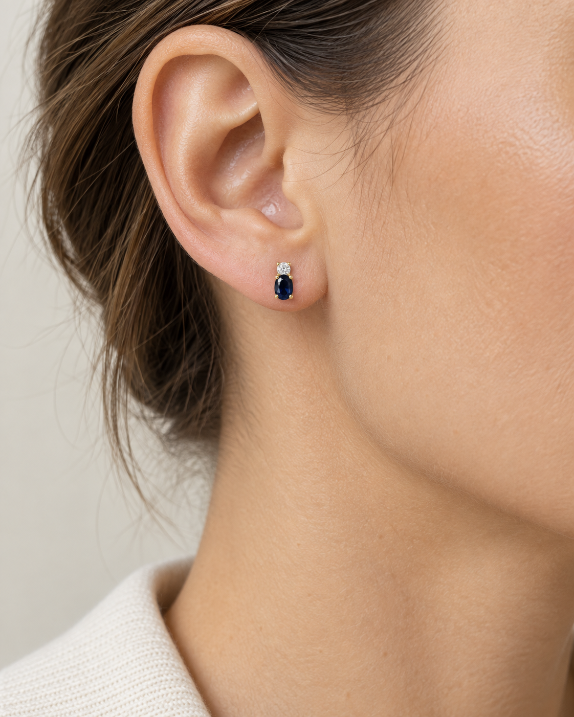 Boucles d’oreilles saphir et oxyde de zirconium en or jaune 9 carats portées par une femme